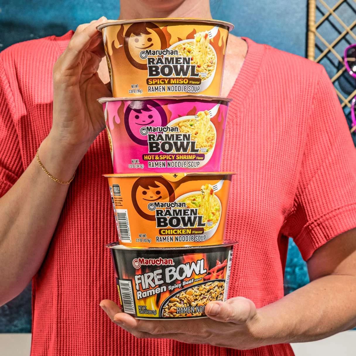 Person holding 4 Maruchan ramen bowls stacked on top of eachother