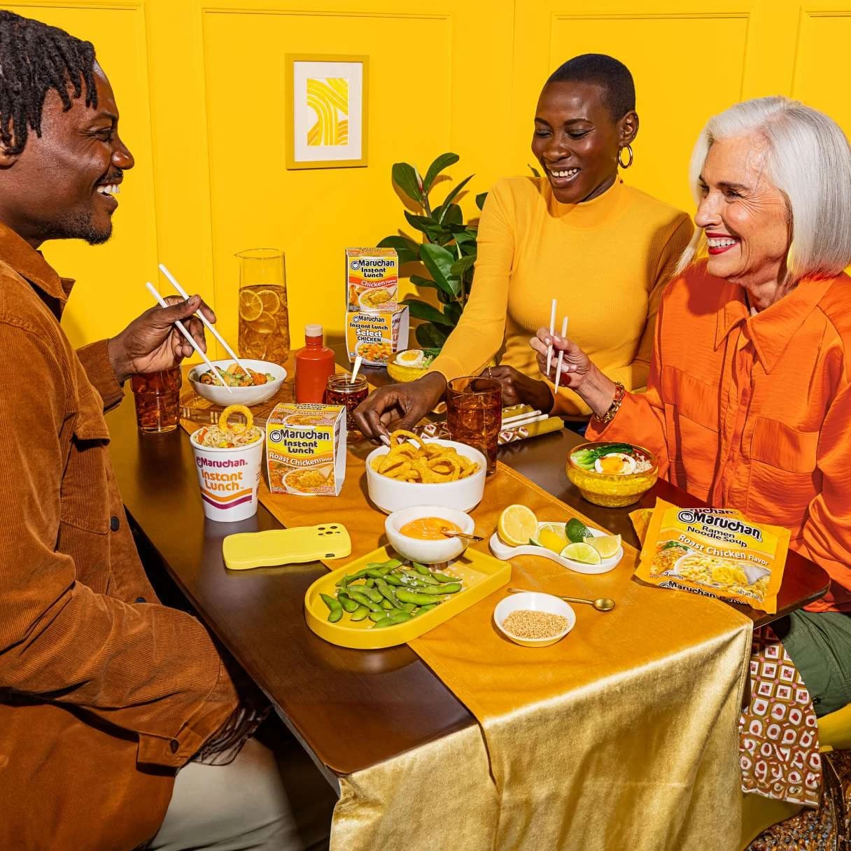 People sitting at a dining table and eating ramen with chopsticks