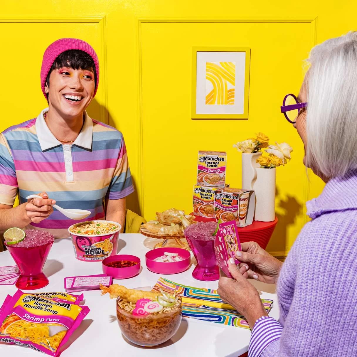 People smiling while eating ramen at a dinner table