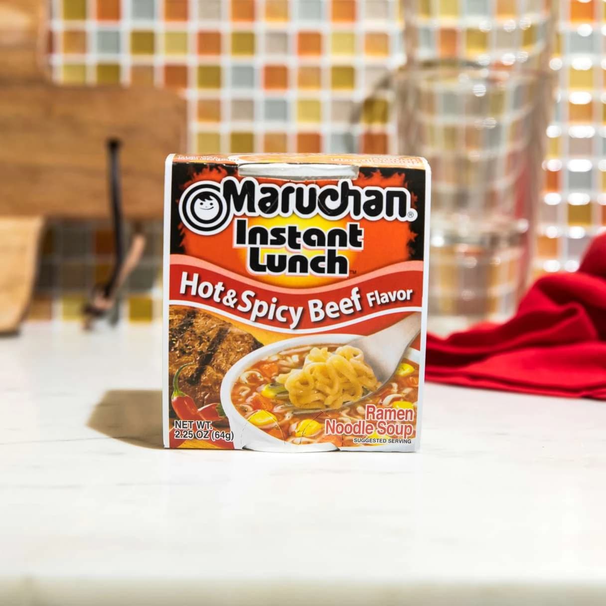Instant lunch hot and spicy beef flavor ramen packaging on a counter
