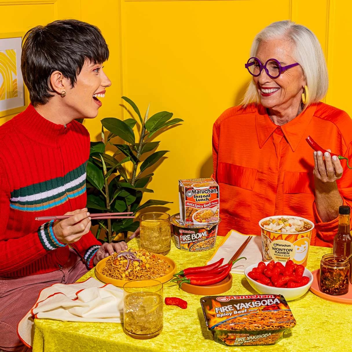People smiling while eating maruchan ramen at a dining table