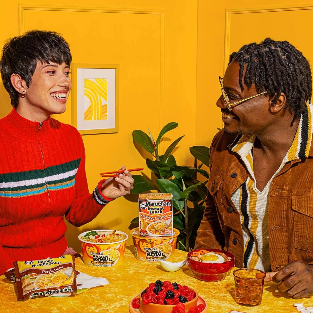 People smiling while eating ramen at a dining table