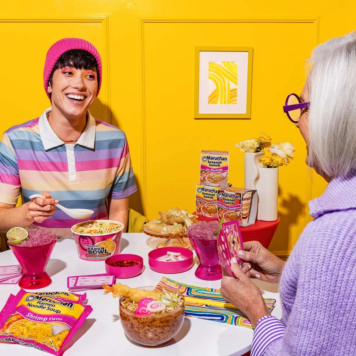 People smiling while eating ramen at a dining table