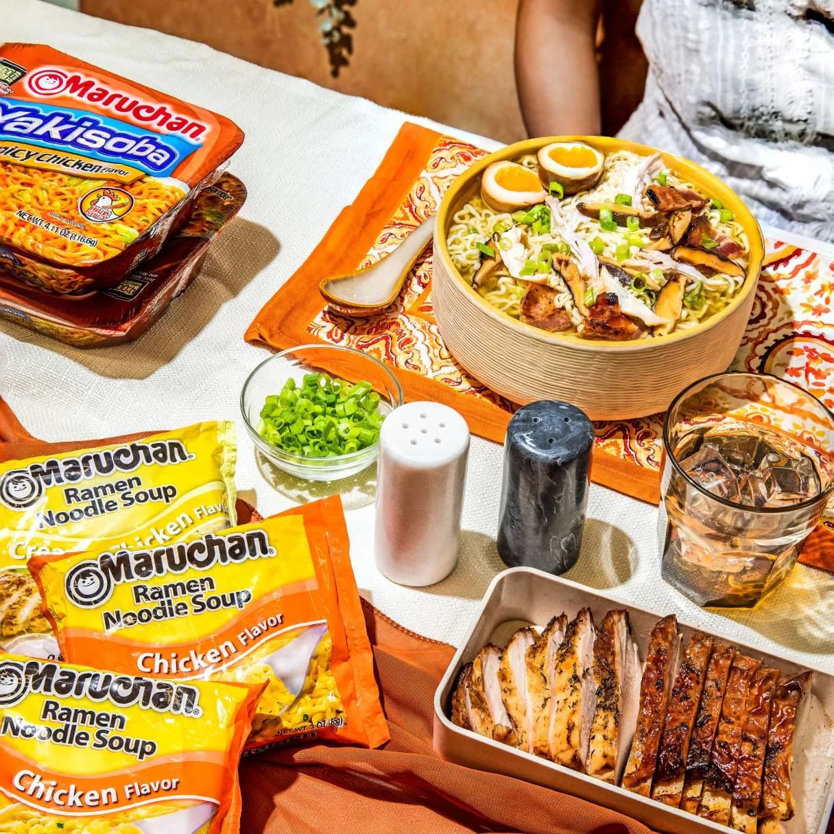 Table with bowl of ramen and ramen packaged products