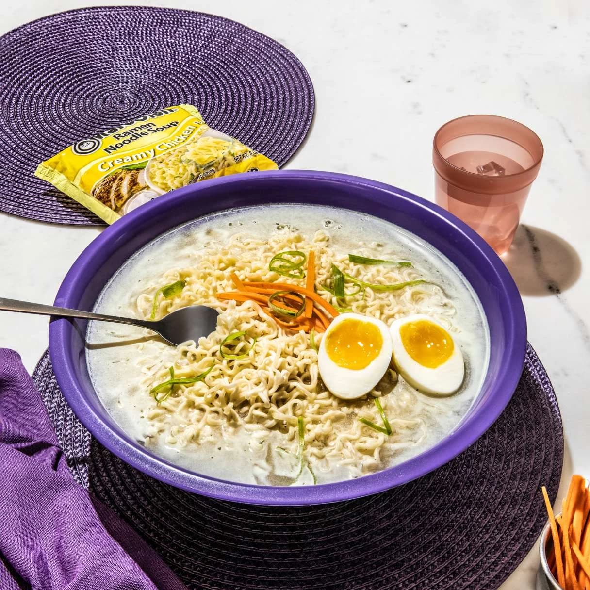 Ramen in a purple bowl on a table setting