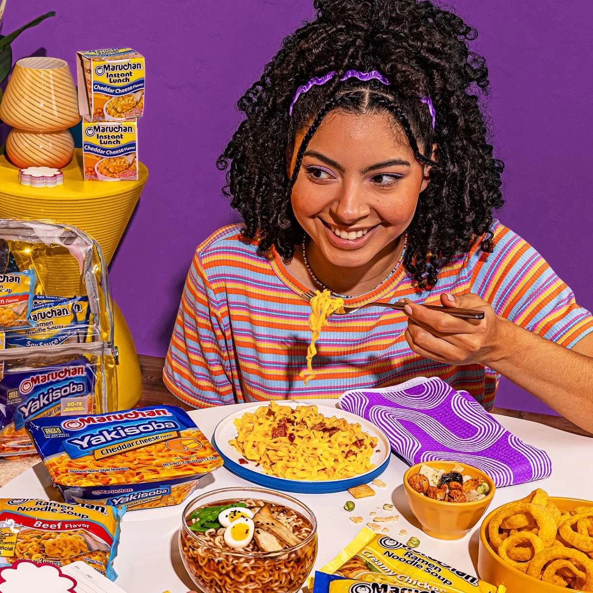 Woman smiling while eating a bowl of ramen
