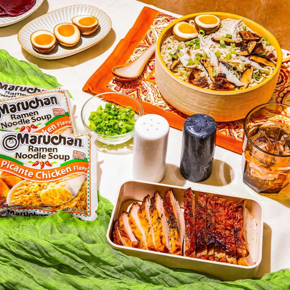 A bowl of ramen at a dining table with Maruchan packages on the table