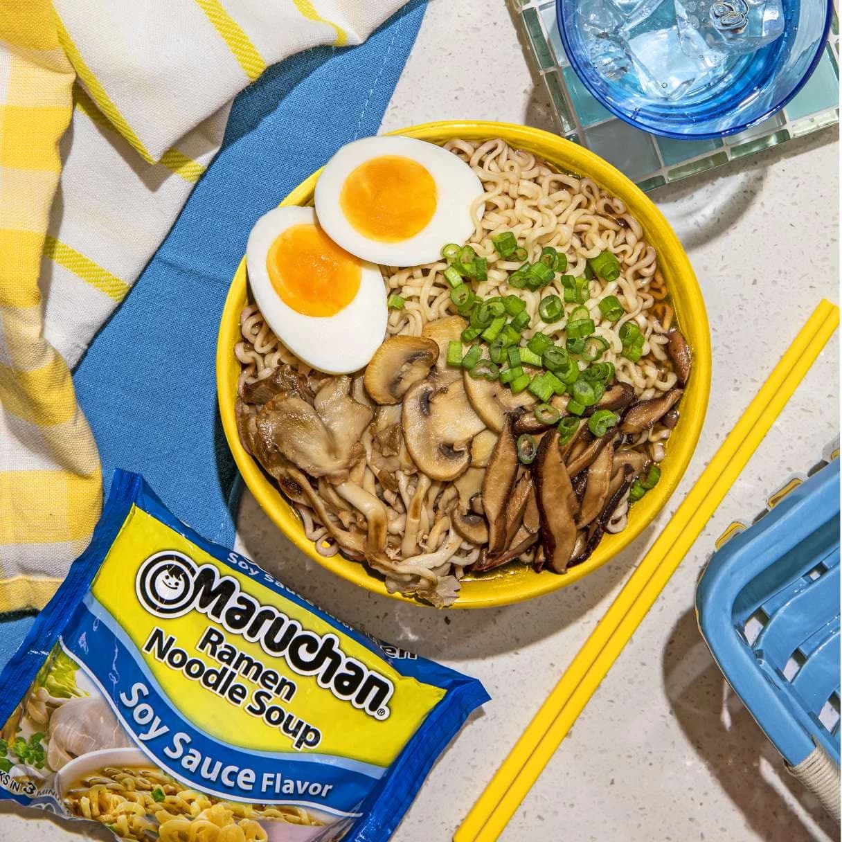 A bowl of ramen next to a package of soy sauce flavor ramen