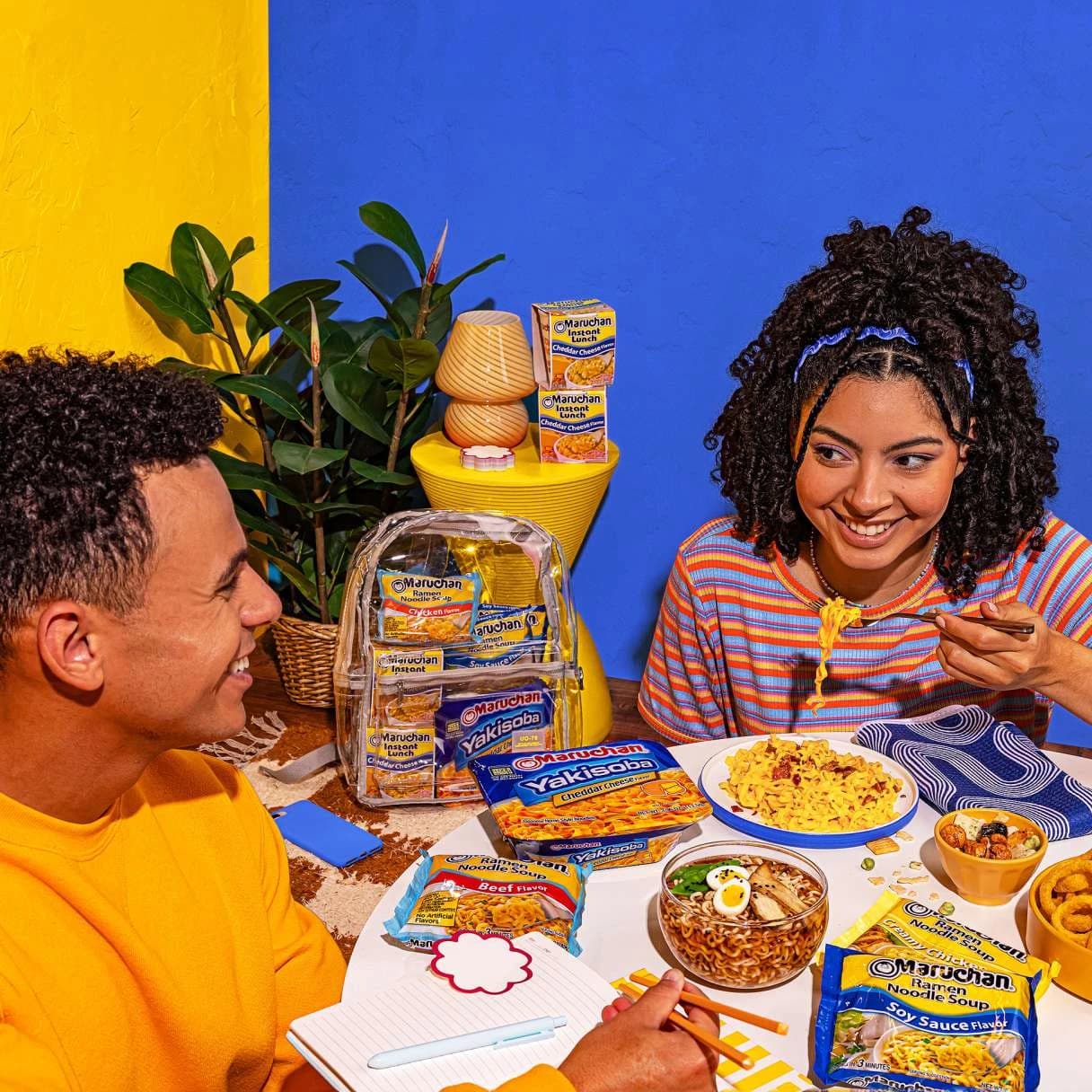 People smiling while eating ramen at a dining table