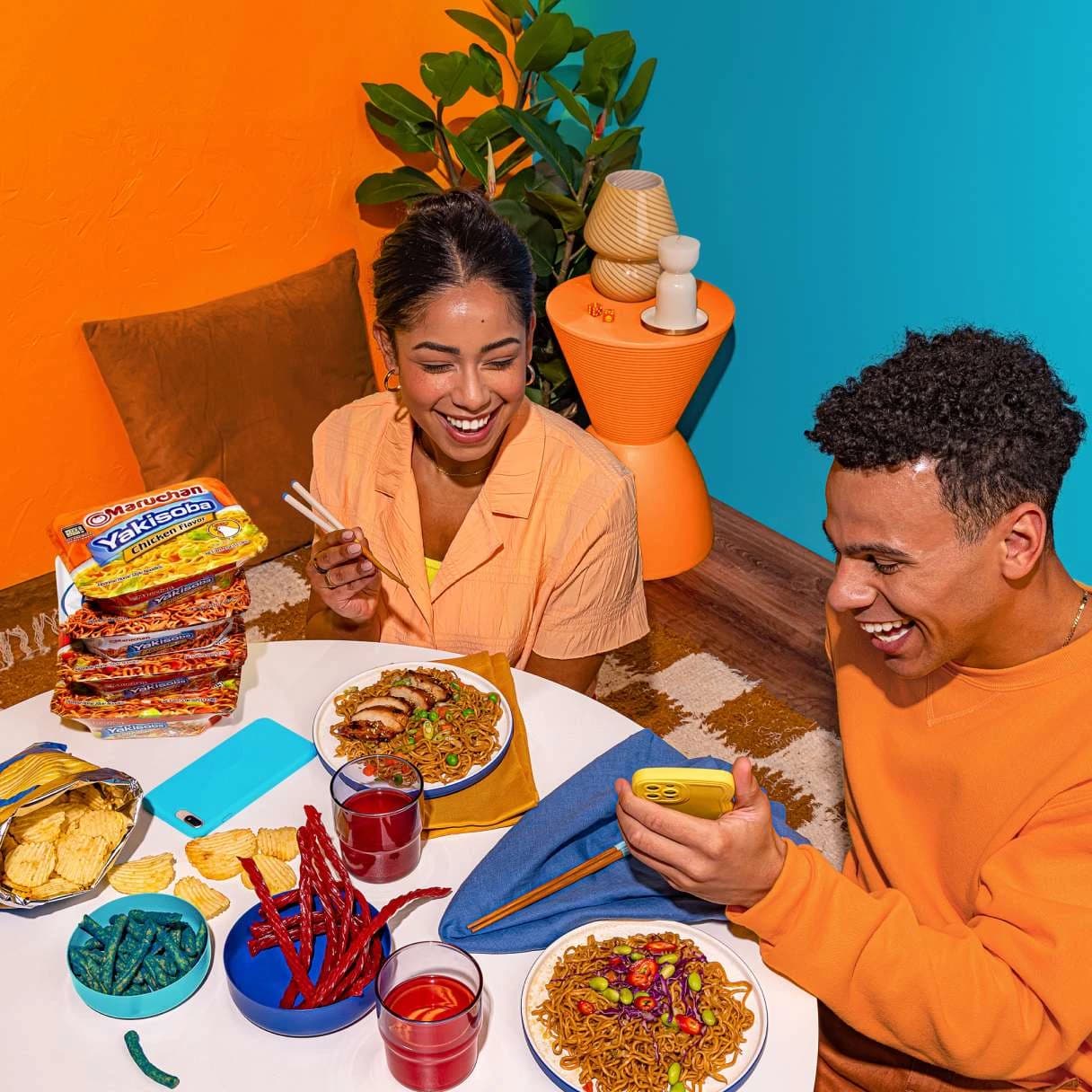 People smiling while eating ramen at a dining table