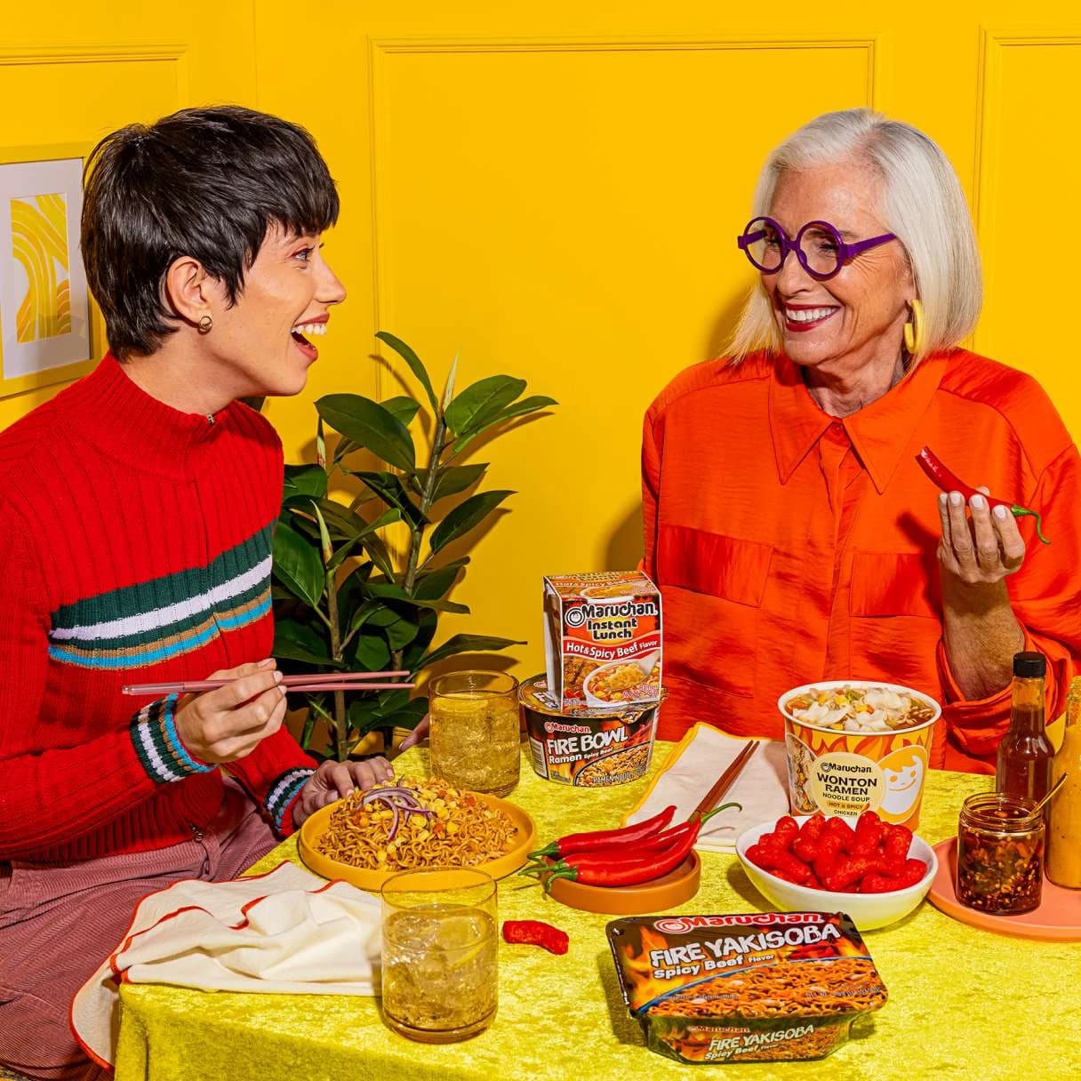 People smiling while eating ramen at a dining table
