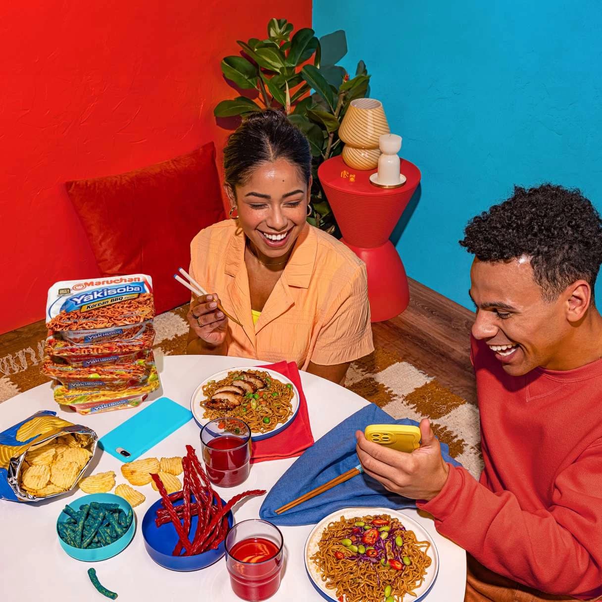 People smiling while eating ramen at a dining table