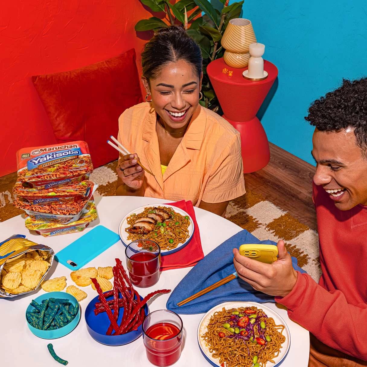 People smiling while eating ramen at a dining table