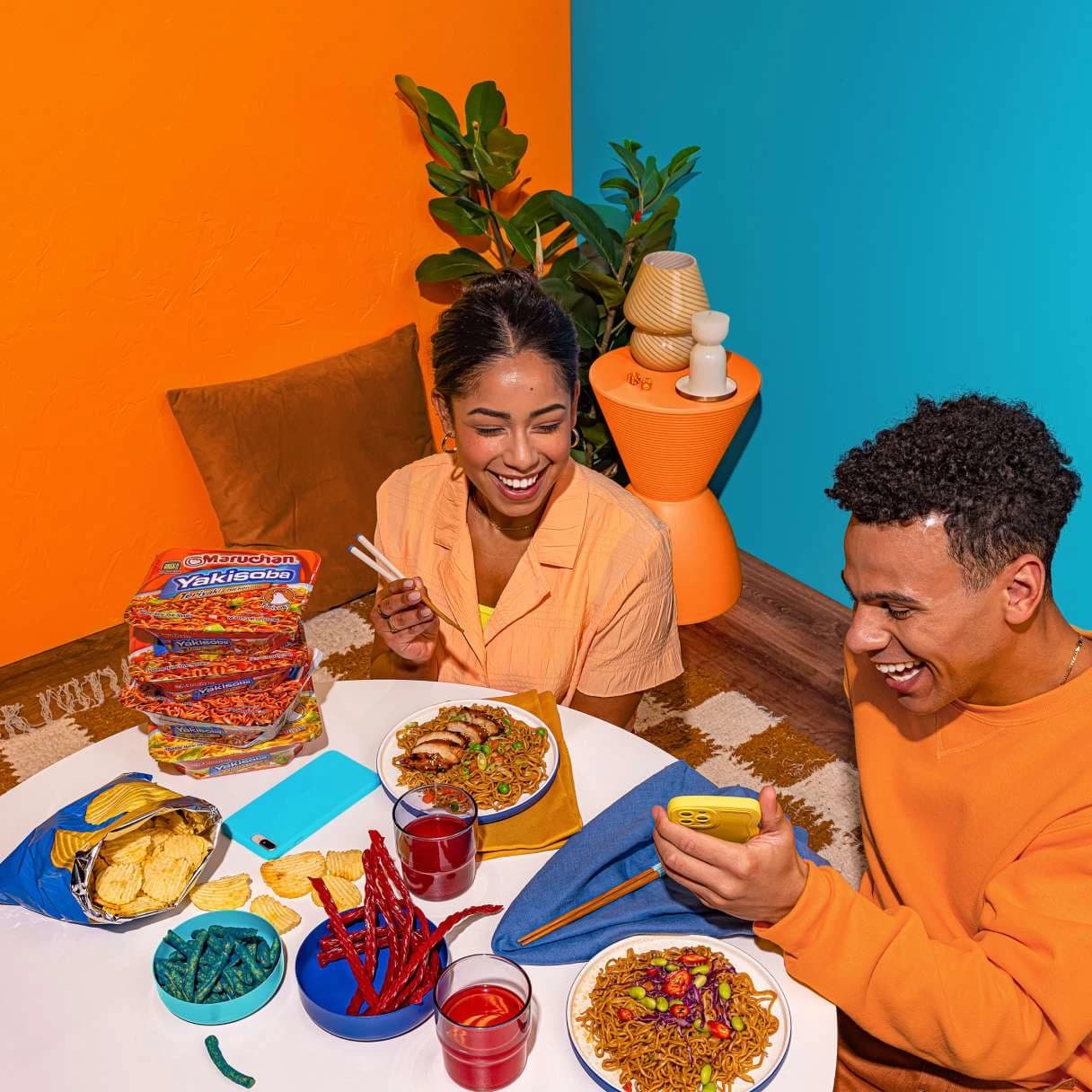 People smiling while eating ramen at a dining table